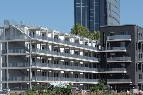 Ein stilvolles, urbanes Wohngebäude mit einer schwarzen und weißen Fassade, eingerahmt von einer städtischen Skyline.