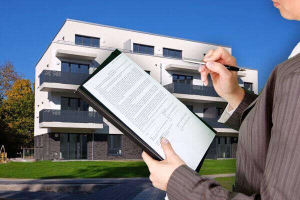 Person hält eine Checkliste vor einem modernen Mehrfamilienhaus. Illustration für den Bereich Immobilienverwaltung oder Wohnungsprüfung.