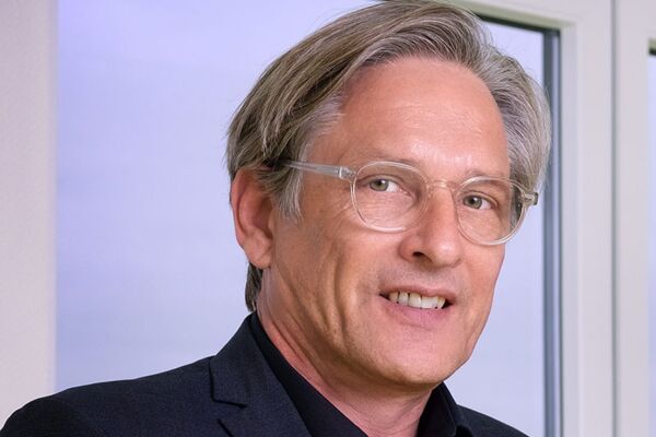 Porträt von Dr. Heinrich Labbert der eine Brille und ein dunkles Sakko trägt und ein freundliches und zugängliches Auftreten zeigt.