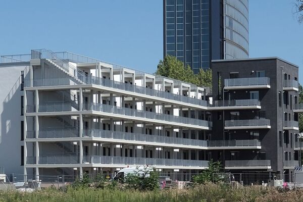 Ein Bild eines mehrstöckigen, modernen Wohngebäudes mit großzügigen Balkonen und klaren Linien, typisch für zeitgenössische städtische Wohnarchitektur.