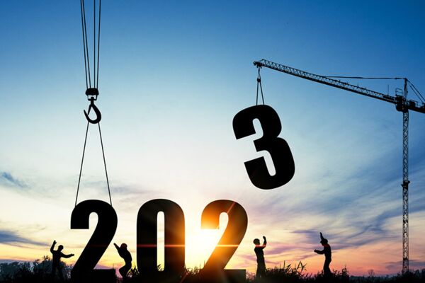 Ein kreatives Bild, das den Übergang ins Jahr 2023 darstellt, mit großen Ziffern, die gegen einen malerischen Sonnenuntergangshimmel gehoben werden.