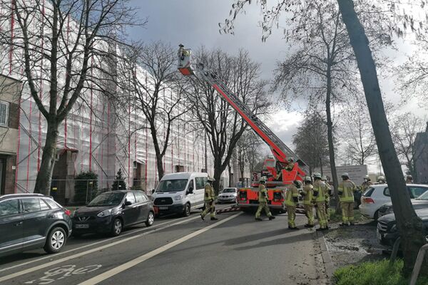 Einsatzkräfte der Feuerwehr in Aktion bei einem Einsatz an einem mit Gerüsten umgebenen Gebäude, unterstreicht die ständige Bereitschaft und Effizienz der städtischen Notfalldienste.