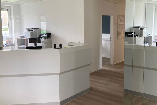 Ein Bild eines modern gestalteten Büroinnenraums mit minimalistischer Einrichtung in neutralen Farben.