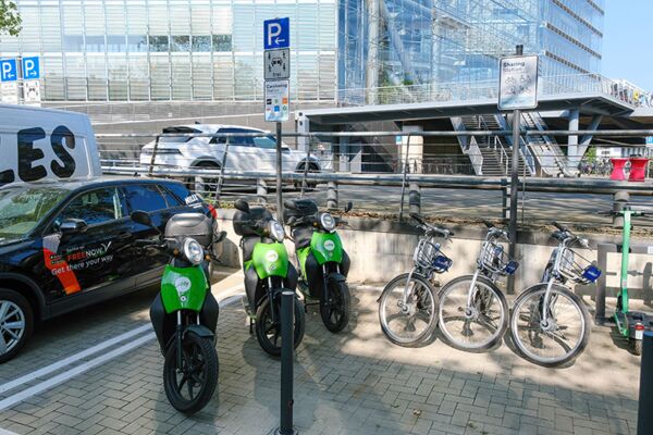Ein Foto einer Mobilitätsstation in Düsseldorf, die verschiedene Transportmittel wie Fahrräder und Elektroroller zeigt und die Vielfalt urbaner Mobilitätsoptionen betont.