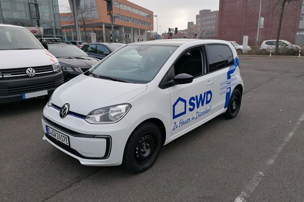 Ein weißer VW Elektro-Van mit SWD-Logo geparkt, symbolisiert umweltfreundliche Firmenmobilität in Düsseldorf.