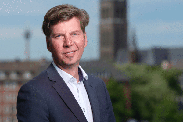 Ein professionelles Porträt vom Geschäftsführers Klaus Feldhaus vor der Kulisse der Stadt Düsseldorf, das Führung und Verantwortung in der Wirtschaft darstellt.