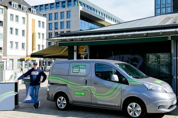 E-Mobilitätsfahrzeug mit dem Branding "Düsselblitz", geparkt in der Innenstadt von Düsseldorf. Eine Initiative für umweltfreundliche Stadtlogistik.