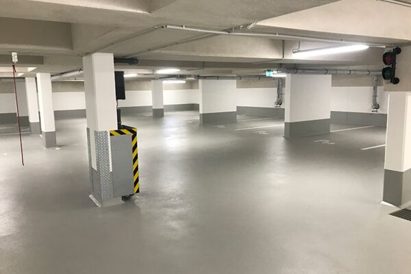 Großzügig gestaltete Tiefgarage in einem Neubau, sauber und übersichtlich mit markierten Parkflächen.